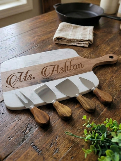 Cheese carving set with personalized wooden paddle on a wooden table
