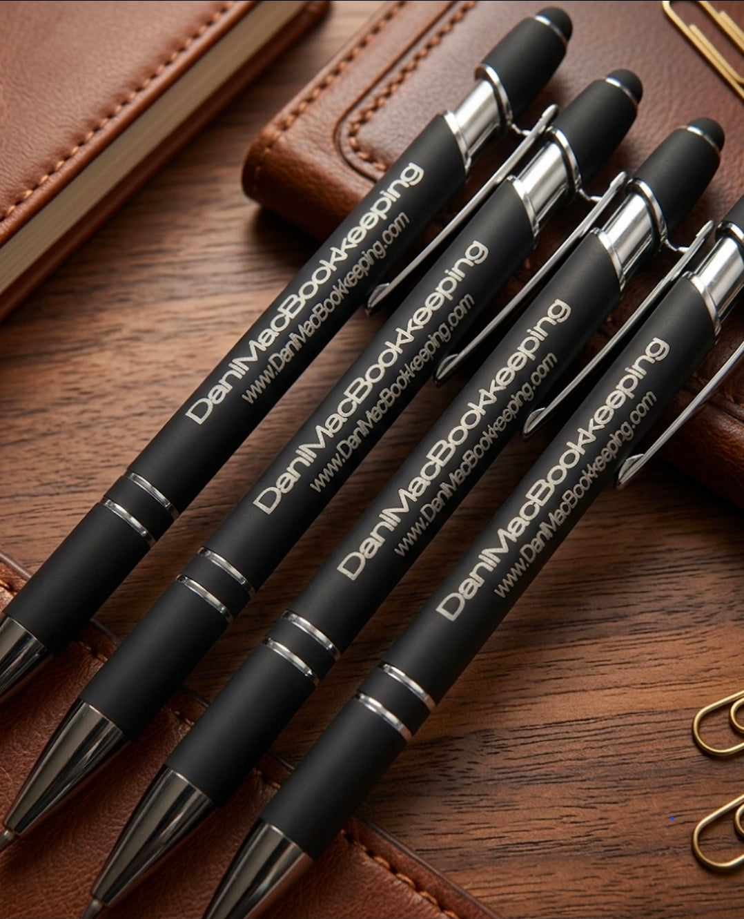 Set of black pens with silver accents on a wooden surface