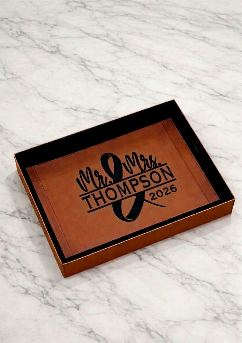 Personalized leather tray with 'Mr & Mrs Thompson 2026' engraving on a marble surface