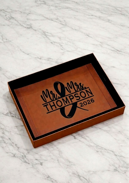 Personalized leather tray with 'Mr & Mrs Thompson 2026' engraving on a marble surface